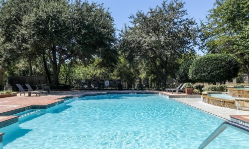 a swimming pool with trees and a blue sky